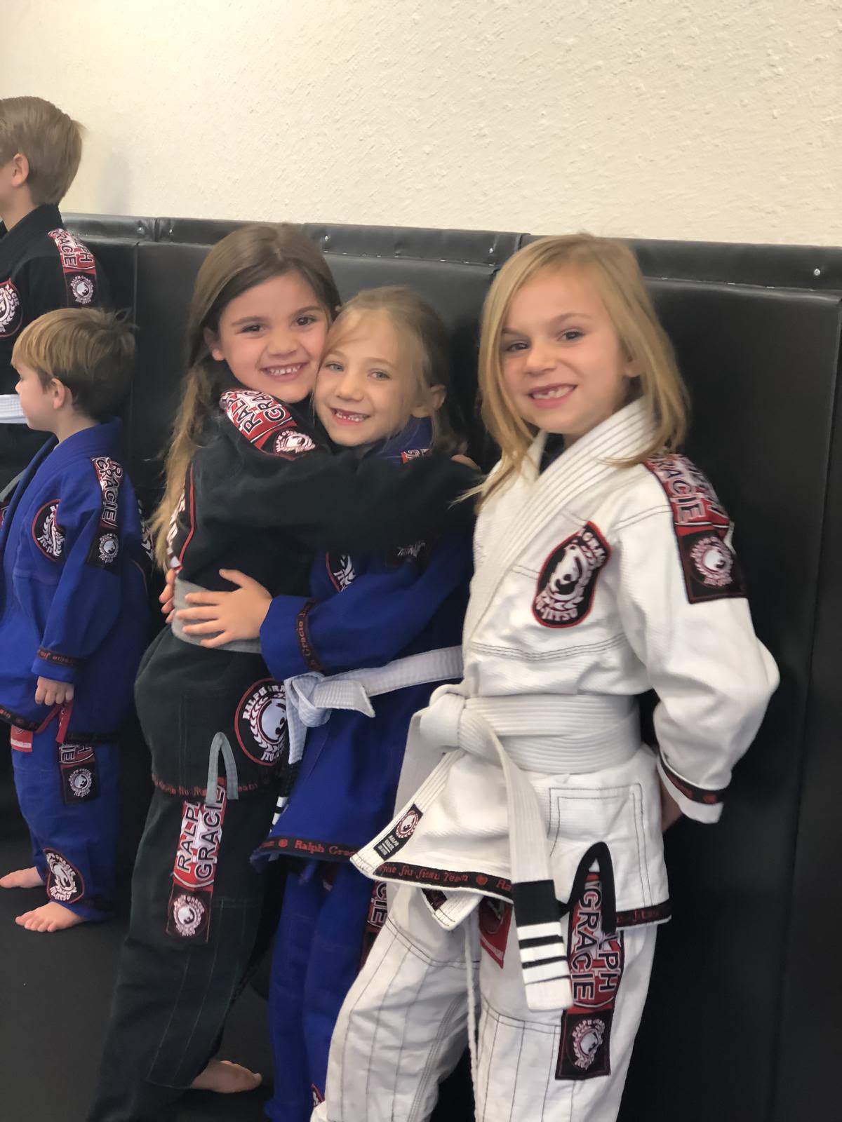 Mission Jiu Jitsu girls teammates hugging and smiling